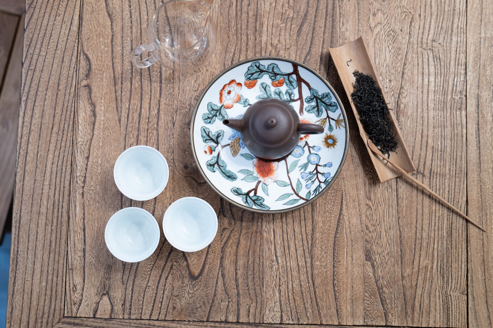 Une théière et des tasses en porcelaine sur un plateau peint